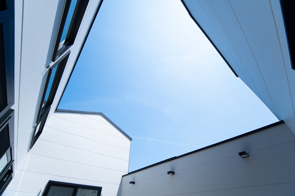 青空を切り取る中庭の屋根ライン｜開放的な空間演出